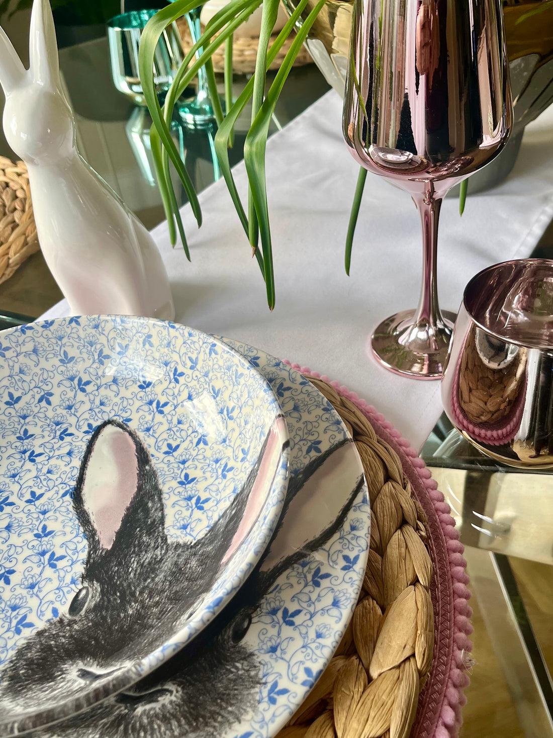 Perfectly set table with classic white table linen, pastel tones glassware and spring bulbs centrepiece 